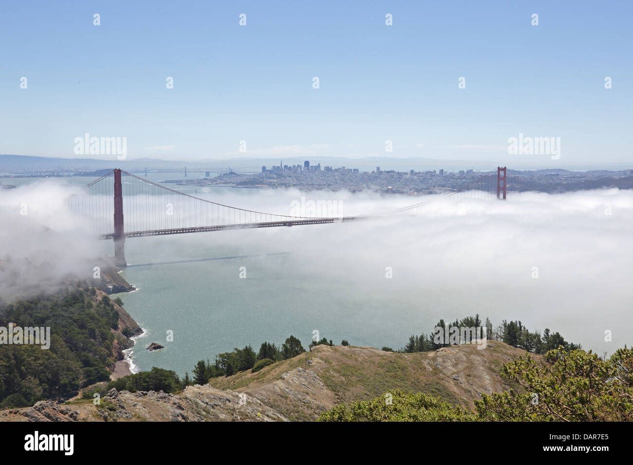 View of the Golden Gate Bridge bathed in fog from Hawk Hill with San Francisco in the background Stock Photo