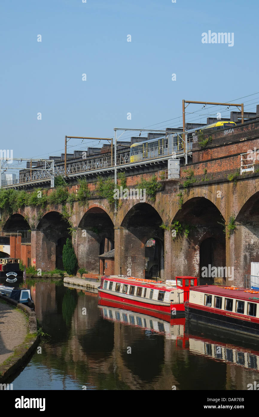 England, Manchester, Victorian Railway line and modern tram plus Canal in foreground Stock Photo