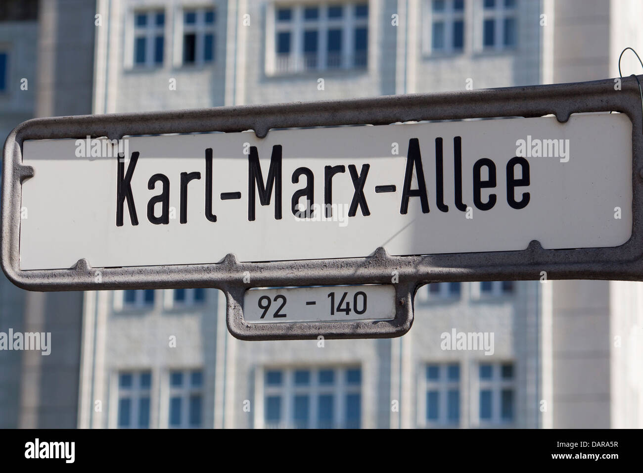 Karl Marx Allee sign with distinctive Socialist Realist buildings behind Friedrichshain Berlin Germany Stock Photo