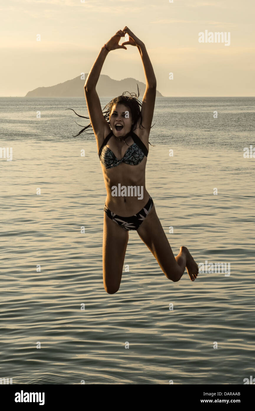 Girl jumping into the water, Porto da Barra, Buzios, Rio de Janeiro, Brazil Stock Photo