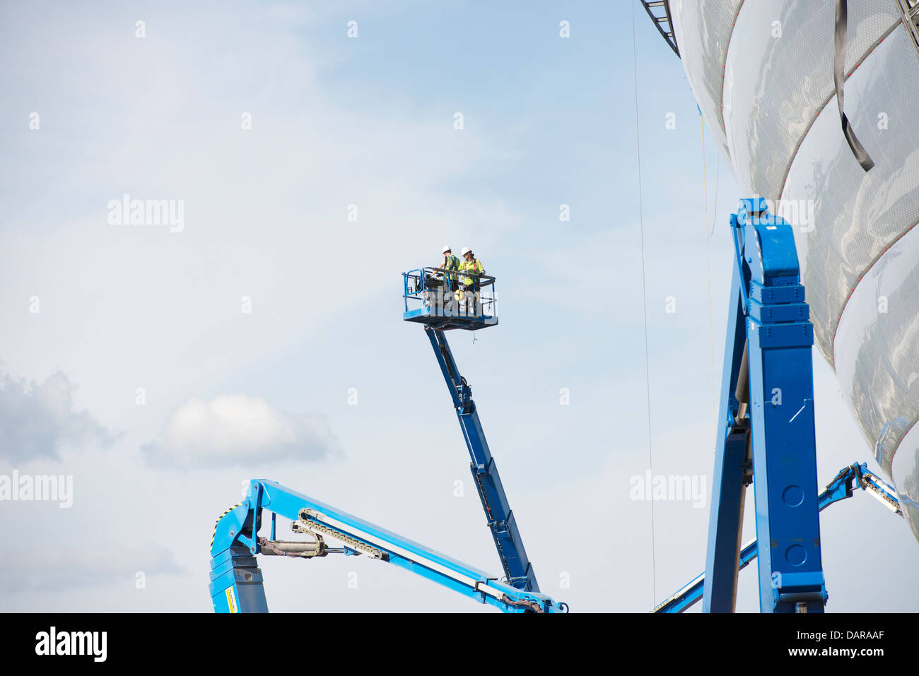 Two construction workers operate a hoist at the SSE Hydro Arena under