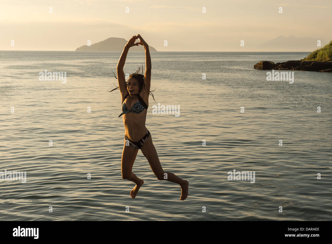 Girl jumping into the water, Porto da Barra, Buzios, Rio de Janeiro, Brazil Stock Photo