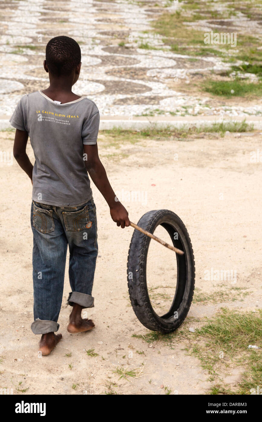 Africa, Mozambique, Mozambique Island. Young boy playing with a rubber tire. Stock Photo