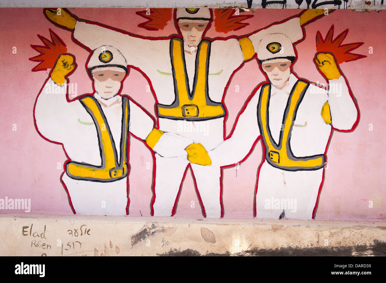 Israel Jaffa Yafo Old City graffiti street art mural 3 three figures in white jumpsuits helmets & yellow webbing & red wings by Elad Rosen Stock Photo