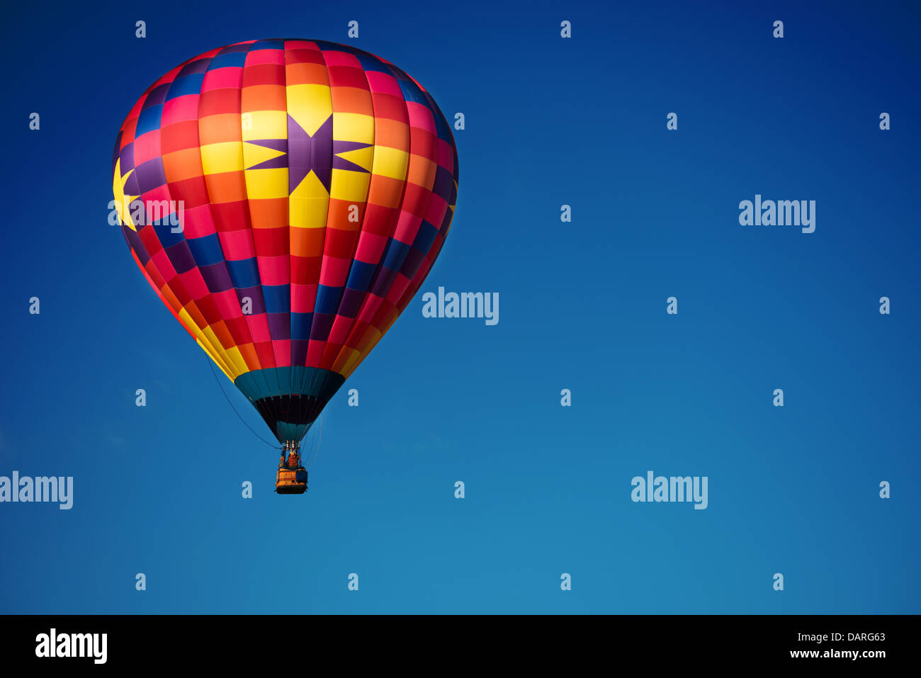 A brightly colored hot air balloon with a sky blue background Stock Photo