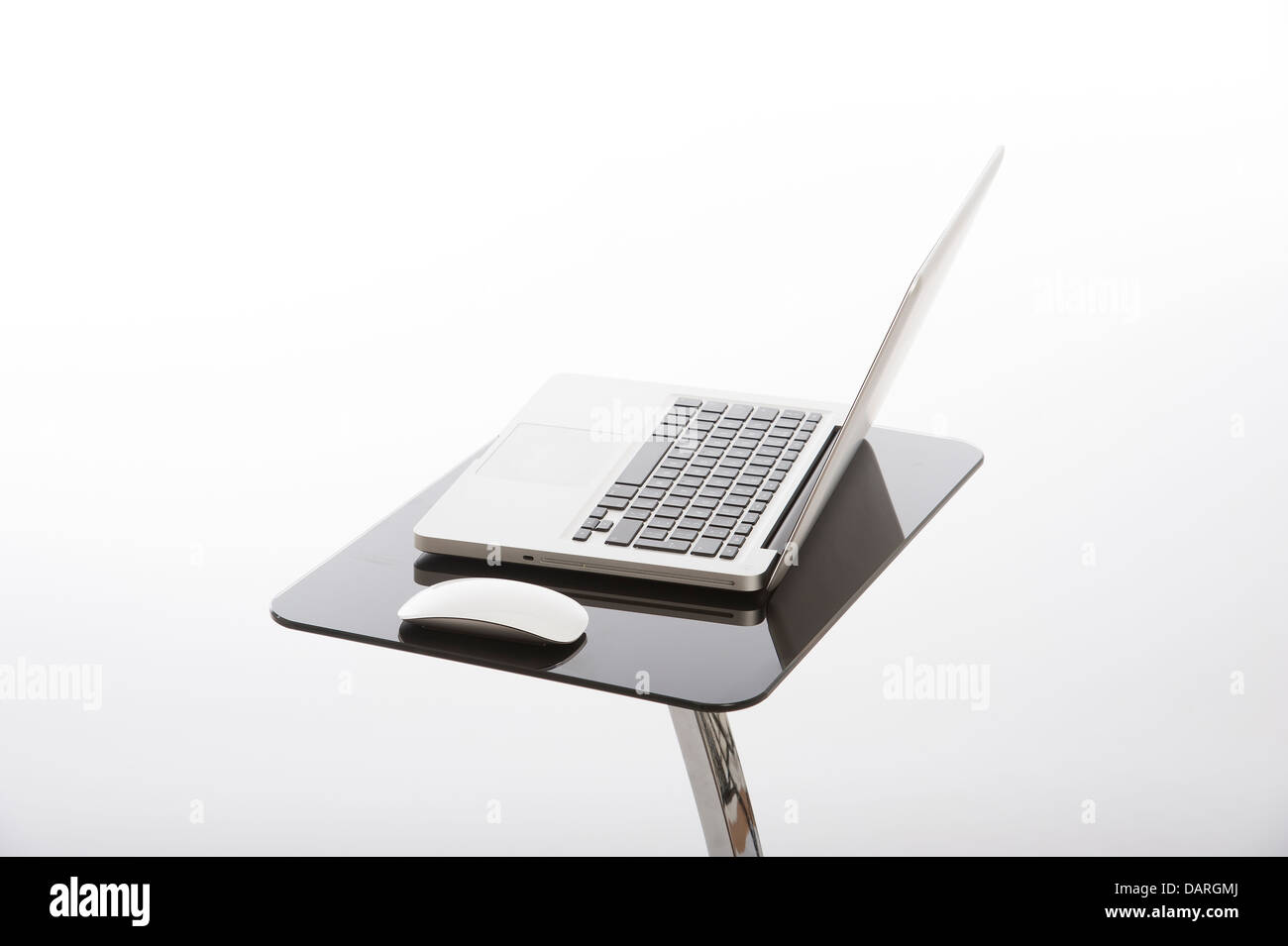 Laptop Computer And Mouse Standing On A Glass Table Stock Photo