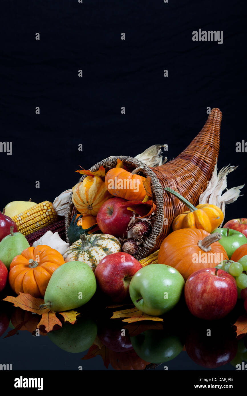 An overflowing cornucopia including pumpkins, grapes, gourds and leaves ...