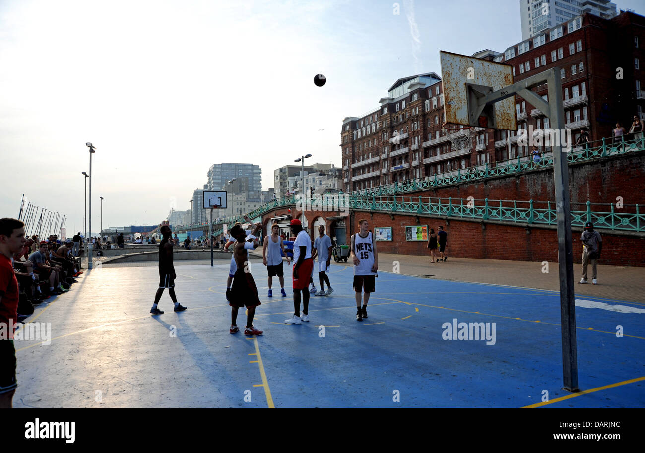 Young men of different nationalities and races playing basketball on Brighton seafront UK Stock Photo