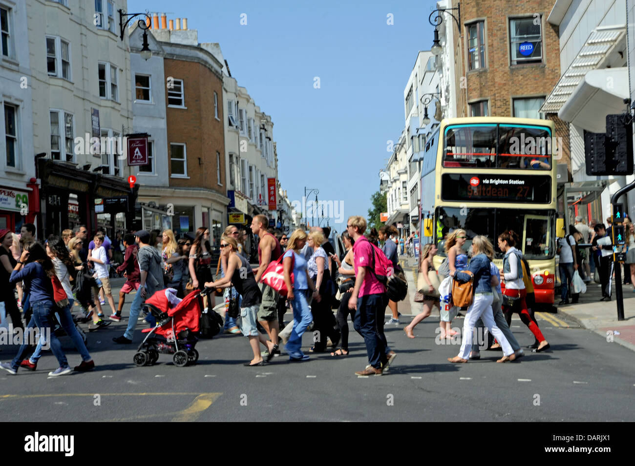 Shoppers crossing busy road on pedestrian crossing in Brighton UK Stock Photo