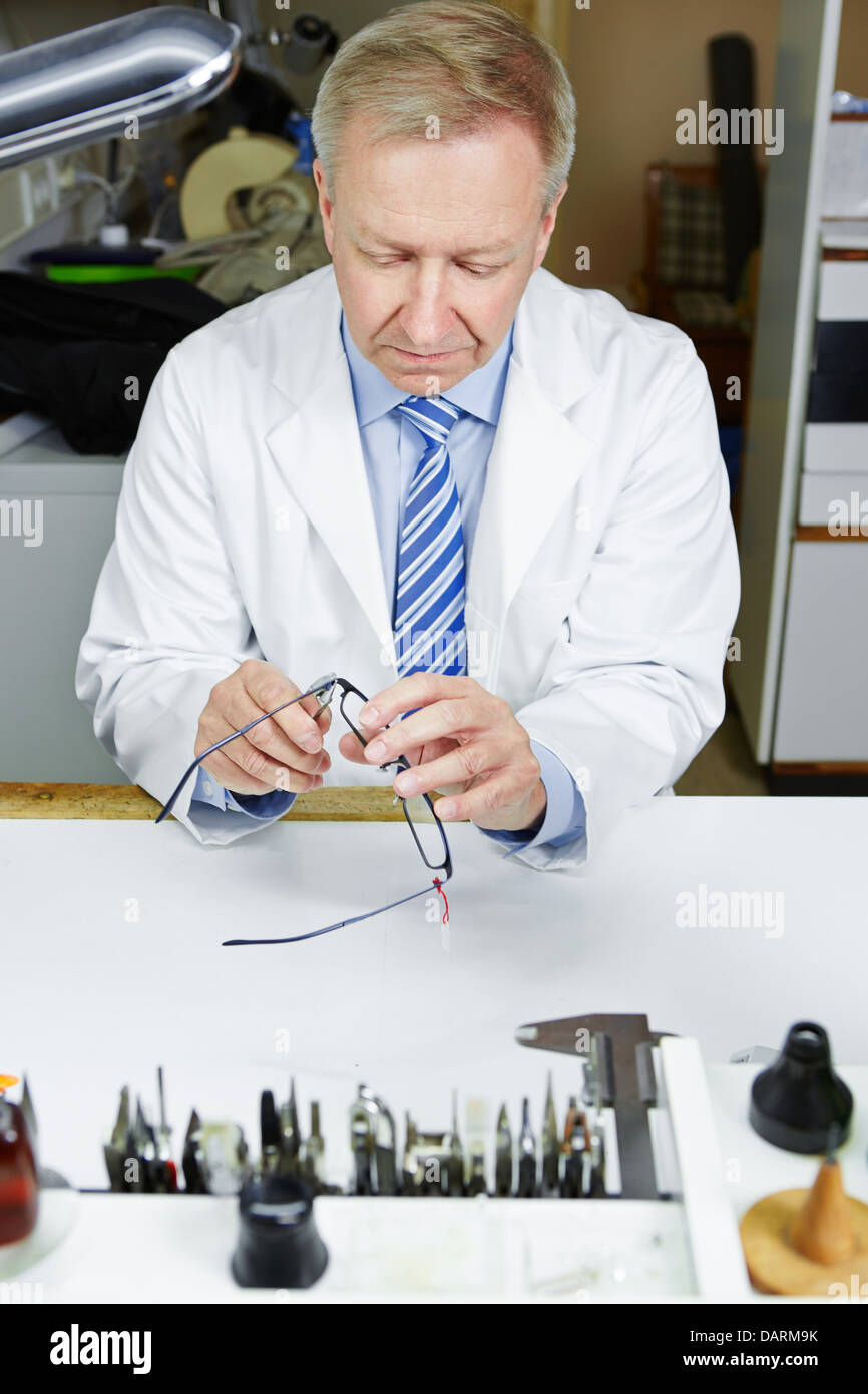 Optician in fixing glasses with pliers Stock Photo Alamy