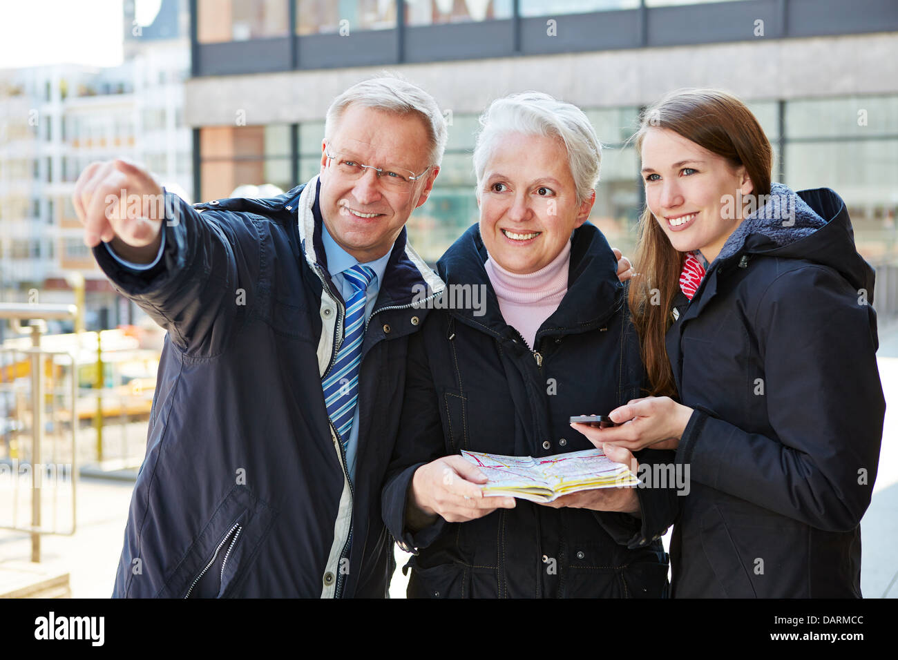 Family with map on sightseeing tour on a city trip Stock Photo