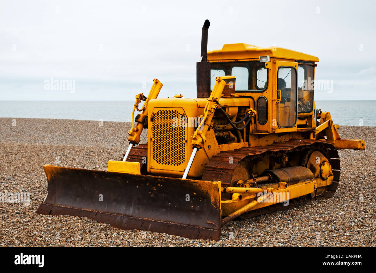 A yellow bulldozer parked on a stoney beech in Suffolk, England Stock ...