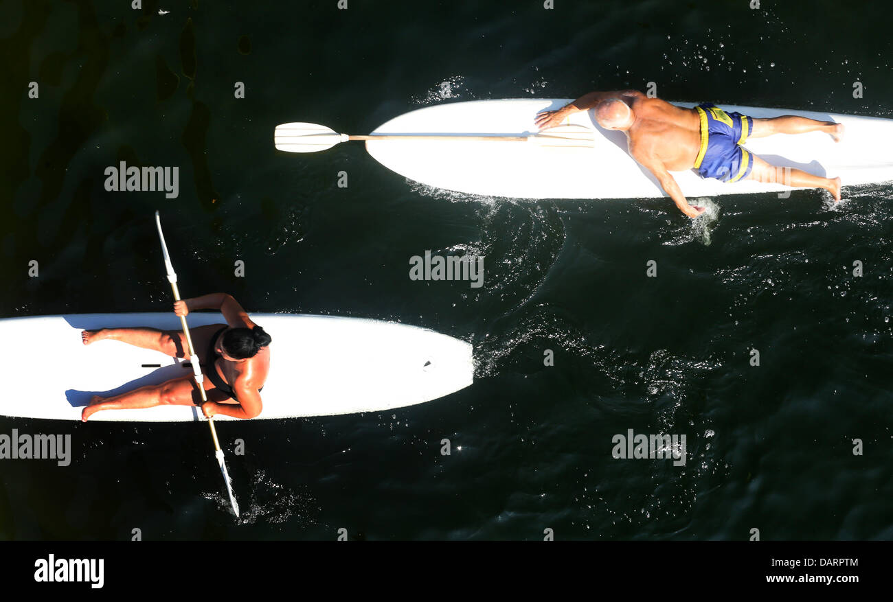 Two men paddle on surf boats across lake Wolfssee in Duisburg, Germany ...