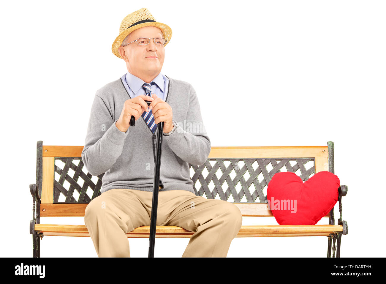 Senior man sitting on a wooden bench with red heart next to him Stock Photo