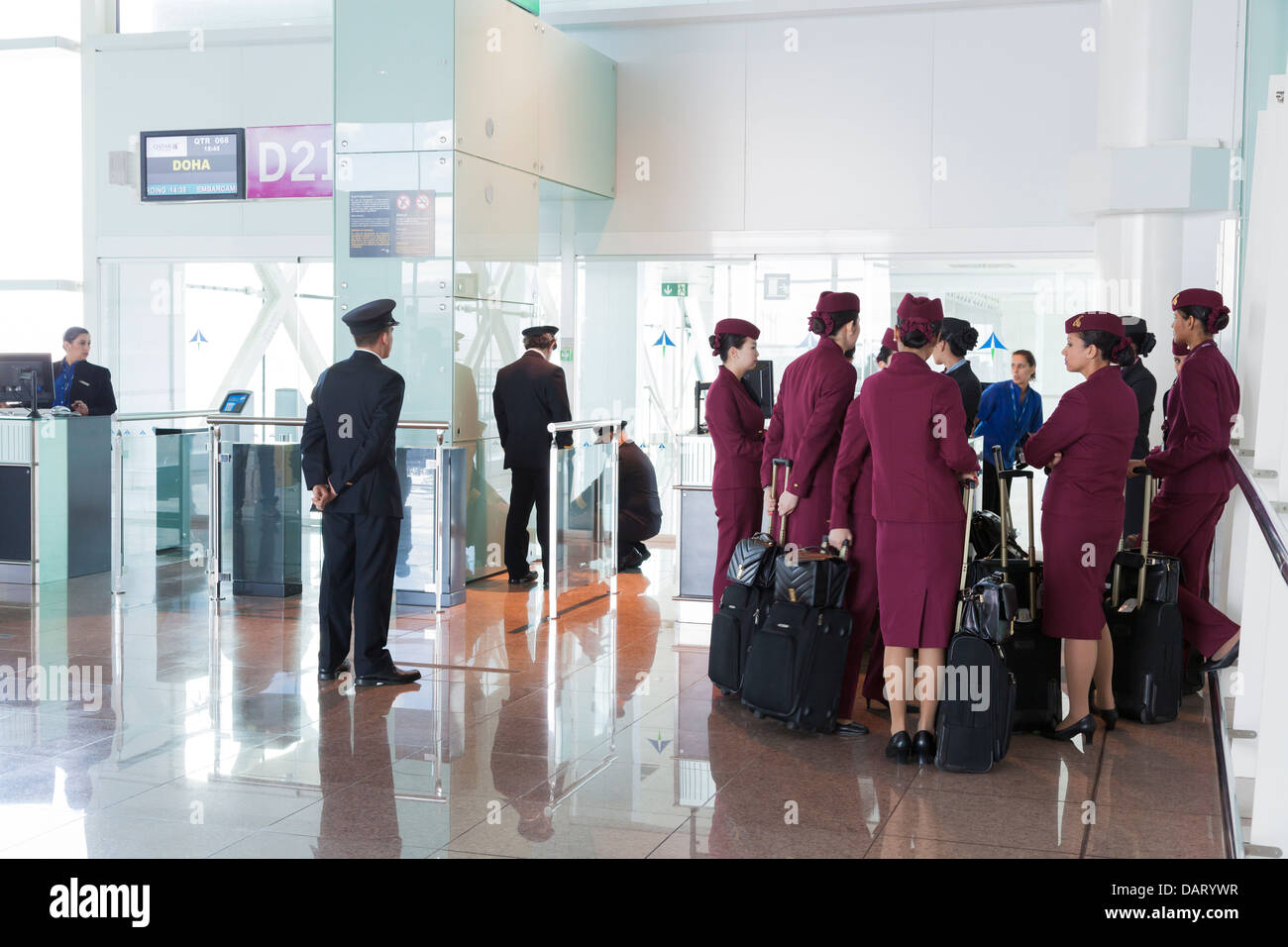 Qatar airways pilots and cabin staff waiting at airport departure gate. Stock Photo