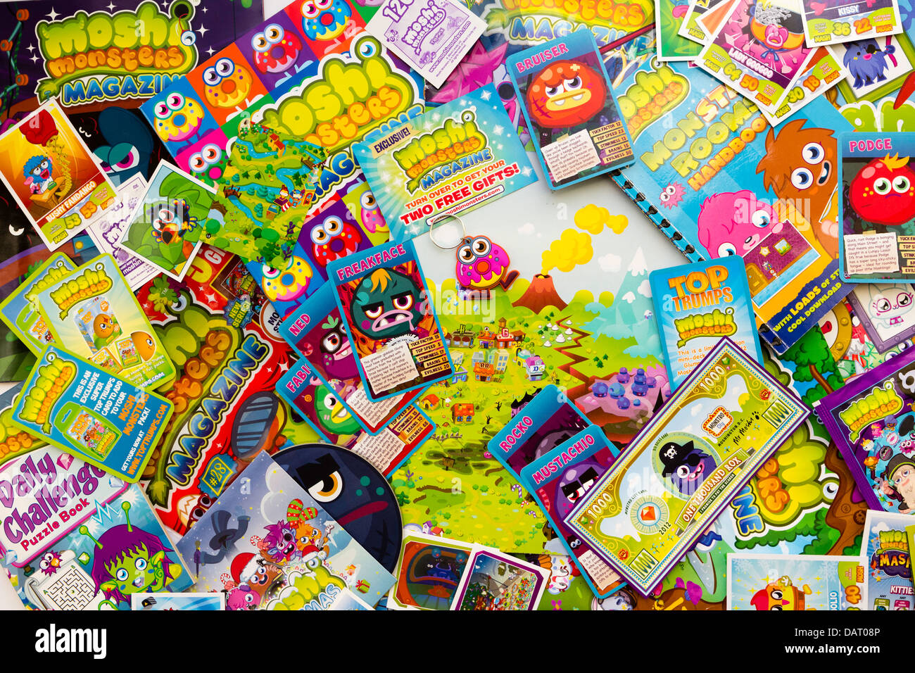 Overhead view of a collection of various children's popular Moshi Monsters comics, trading cards and related ephemera scattered on top of each other. Stock Photo