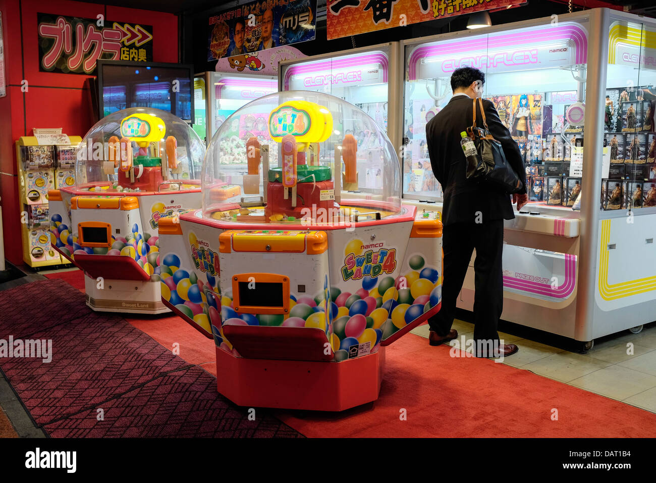 A Japanese Businessman playing an Arcade Claw Crane Game, Dotonburi, Osaka, Japan Stock Photo