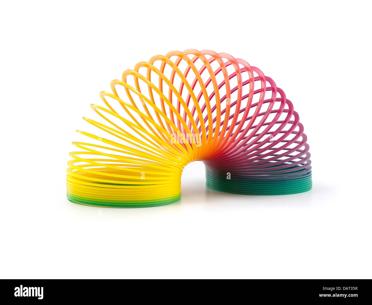 rainbow slinky cut out onto a white background Stock Photo
