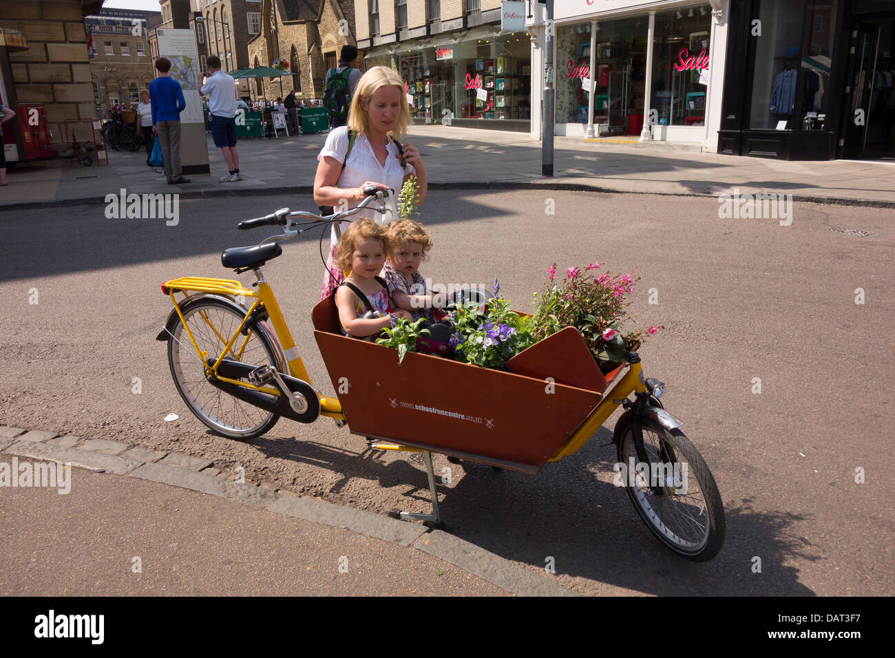 Lady and two children with special bicycle and flowers Cambridge city England Stock Photo