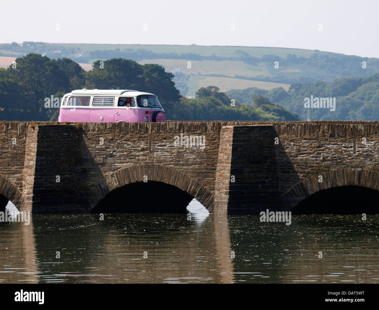 Pink VW going over bridge on the A379 over the Bowcombe Creek, near Kingsbridge, Devon, UK 2013 Stock Photo