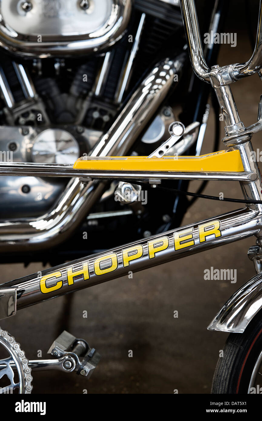 Chrome Raleigh Chopper bicycle in front of a Harley Davidson motorcycle Stock Photo