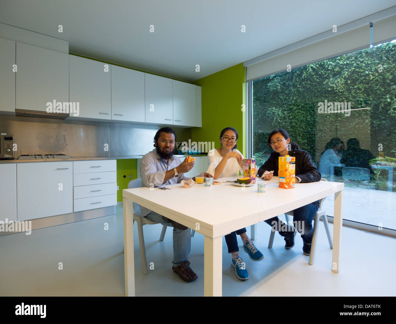 Friends eating breakfast in modern kitchen Stock Photo