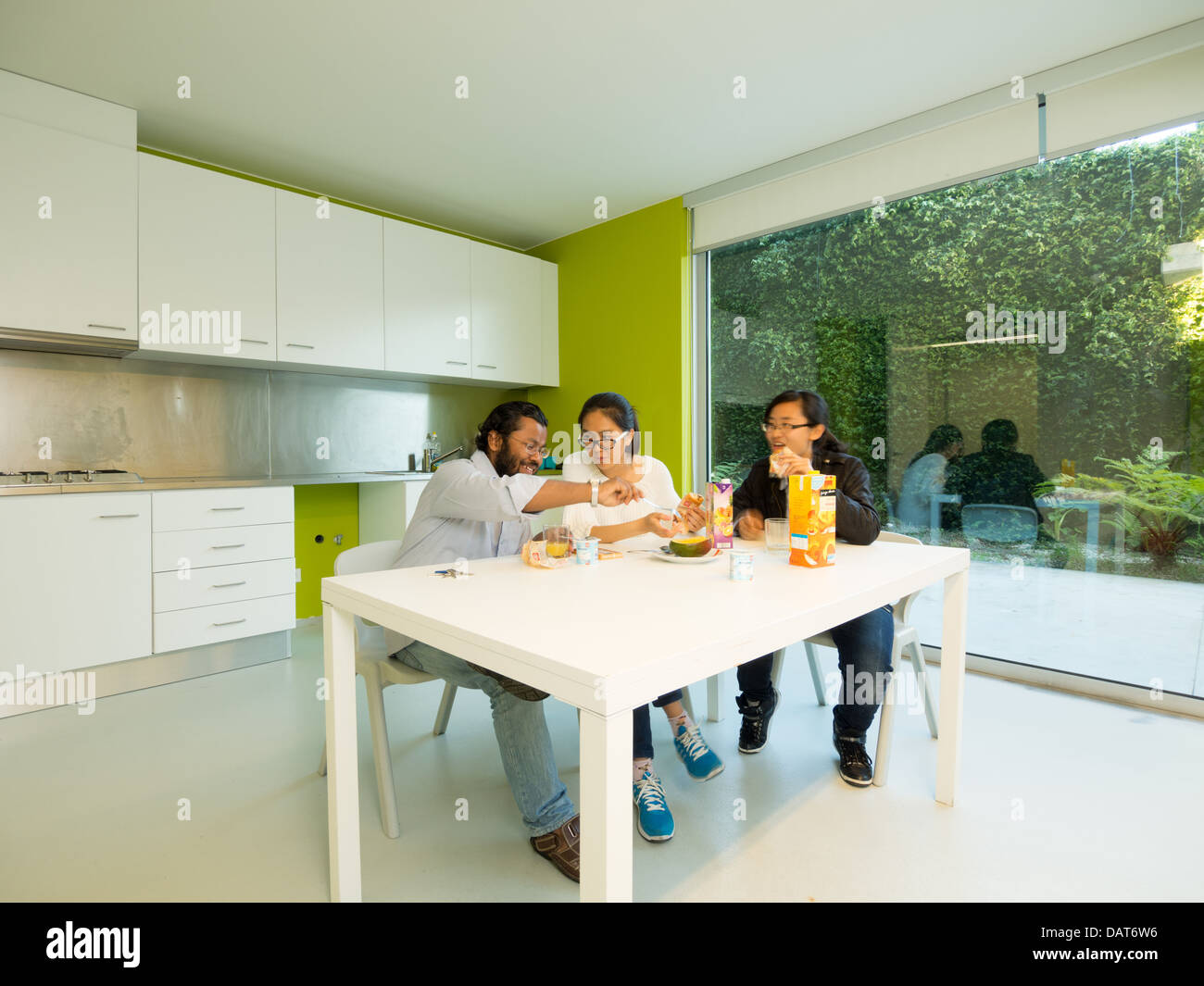 Friends eating breakfast in modern kitchen Stock Photo