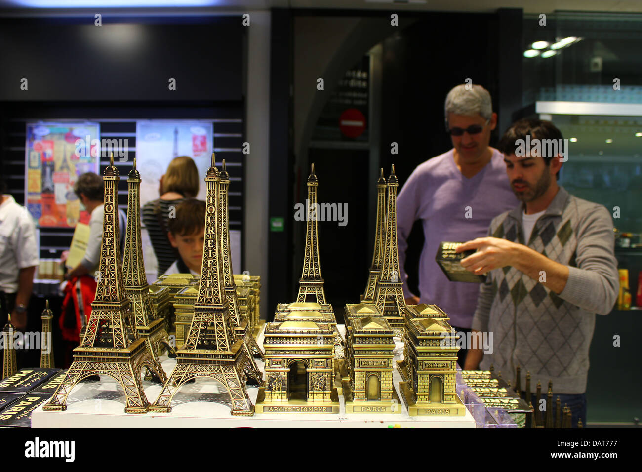 Tourist shop inside of the Arc de Triomphe - miniature Eiffel Towers and mini triumphal archs with people on the background Stock Photo