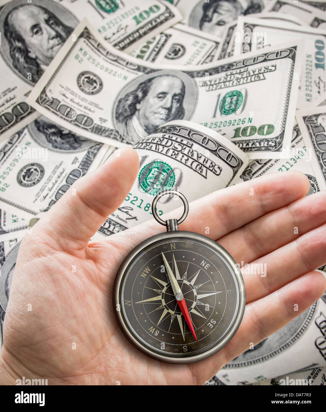 Hand with compass over hundred dollars. Finance concept. Stock Photo