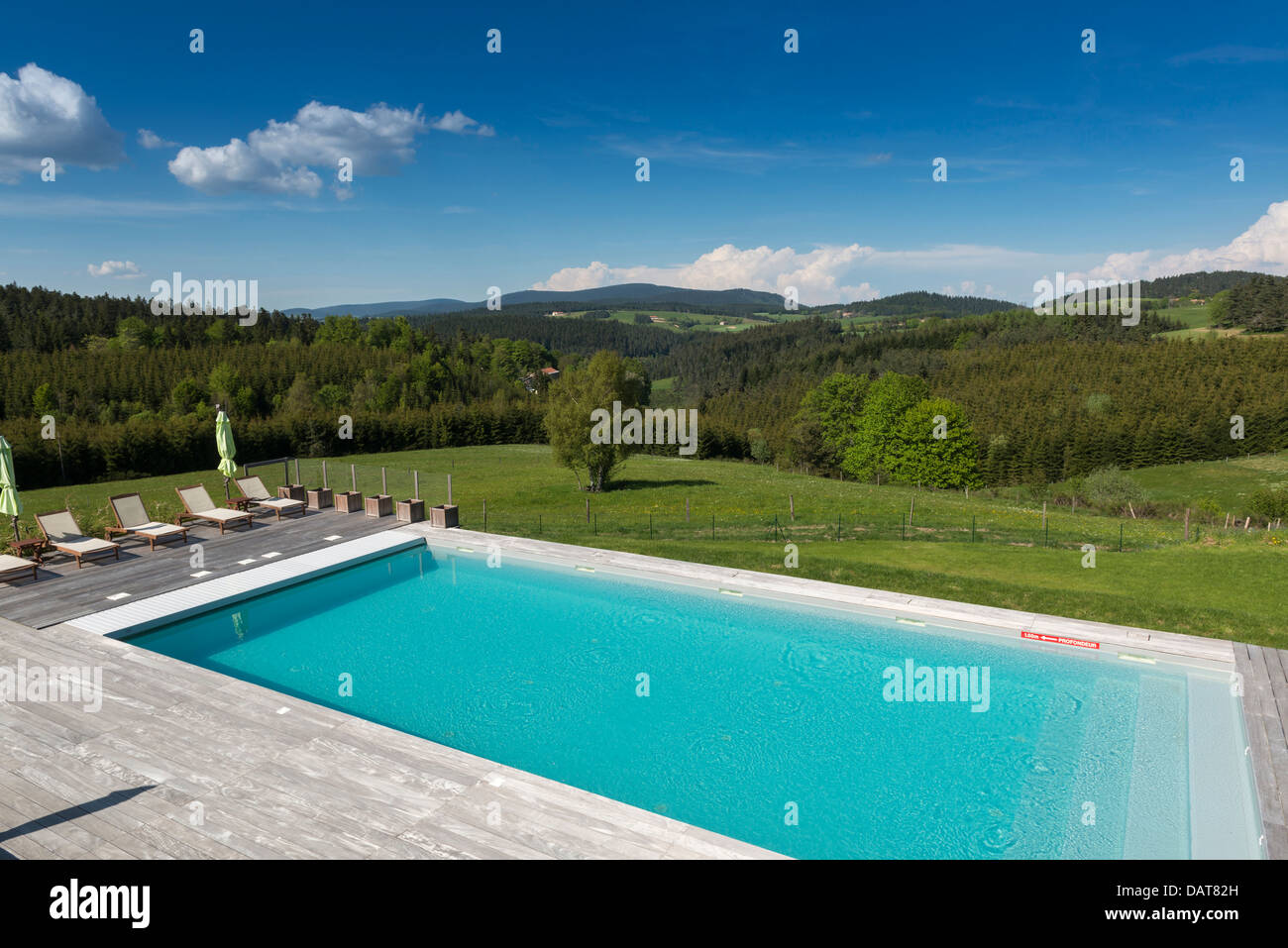 Outdoor swimming pool with a panoramic view of the Haute- Loire. Le Fort du Pré boutique hotel. Saint-Bonnet-le-Froid. Auvergne Stock Photo
