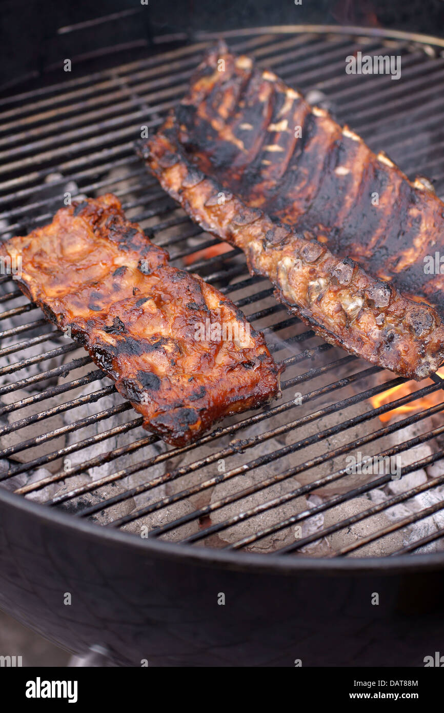 Marinated pork and beef ribs cooking on a domestic barbecue Stock Photo
