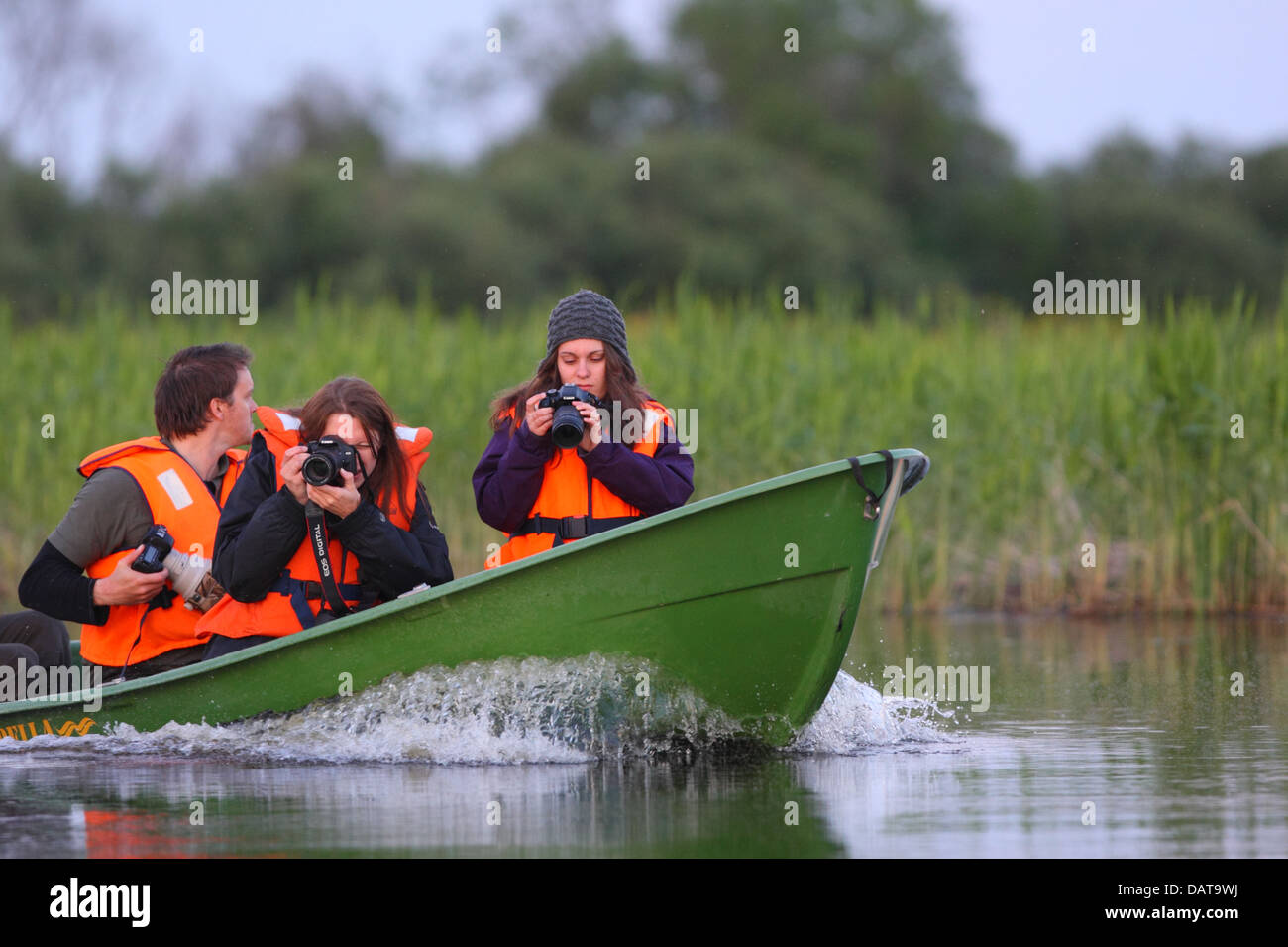 Group of wildlife photographers taking a boat ride. Europe, Estonia, Alam-Pedja Nature Reserve. Stock Photo