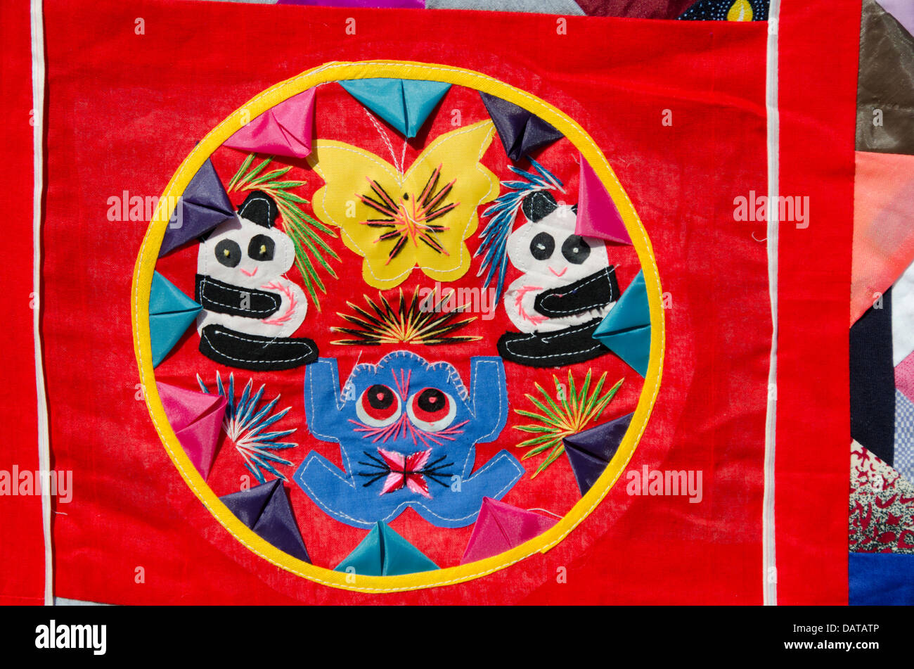 China, Beijing. Traditional Chinese handicrafts. Colorful Chinese embroidery quilt with panda bears and frog design. Stock Photo