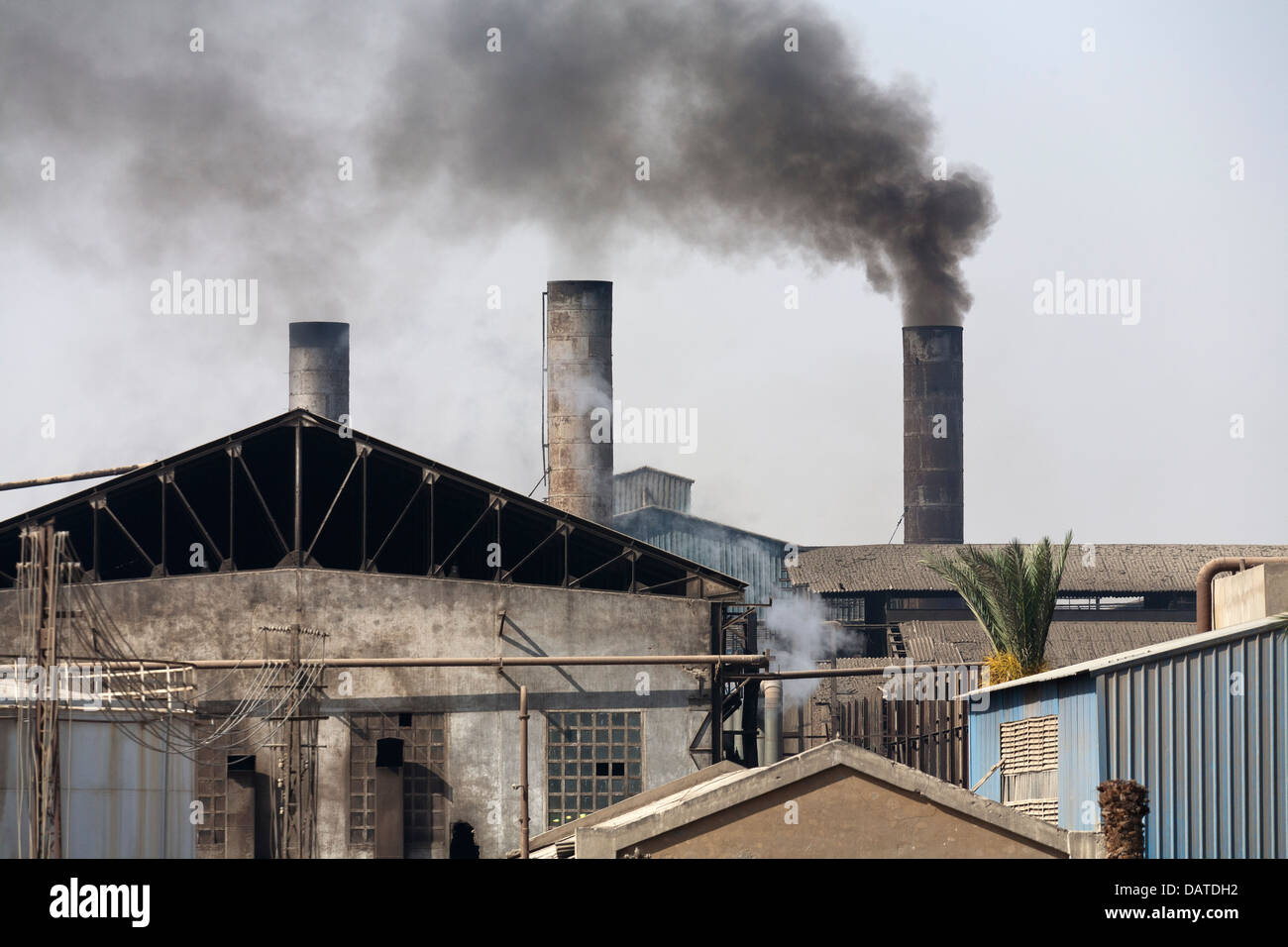Smoking factory chimneys on the banks of the river Nile Egypt Africa Stock Photo