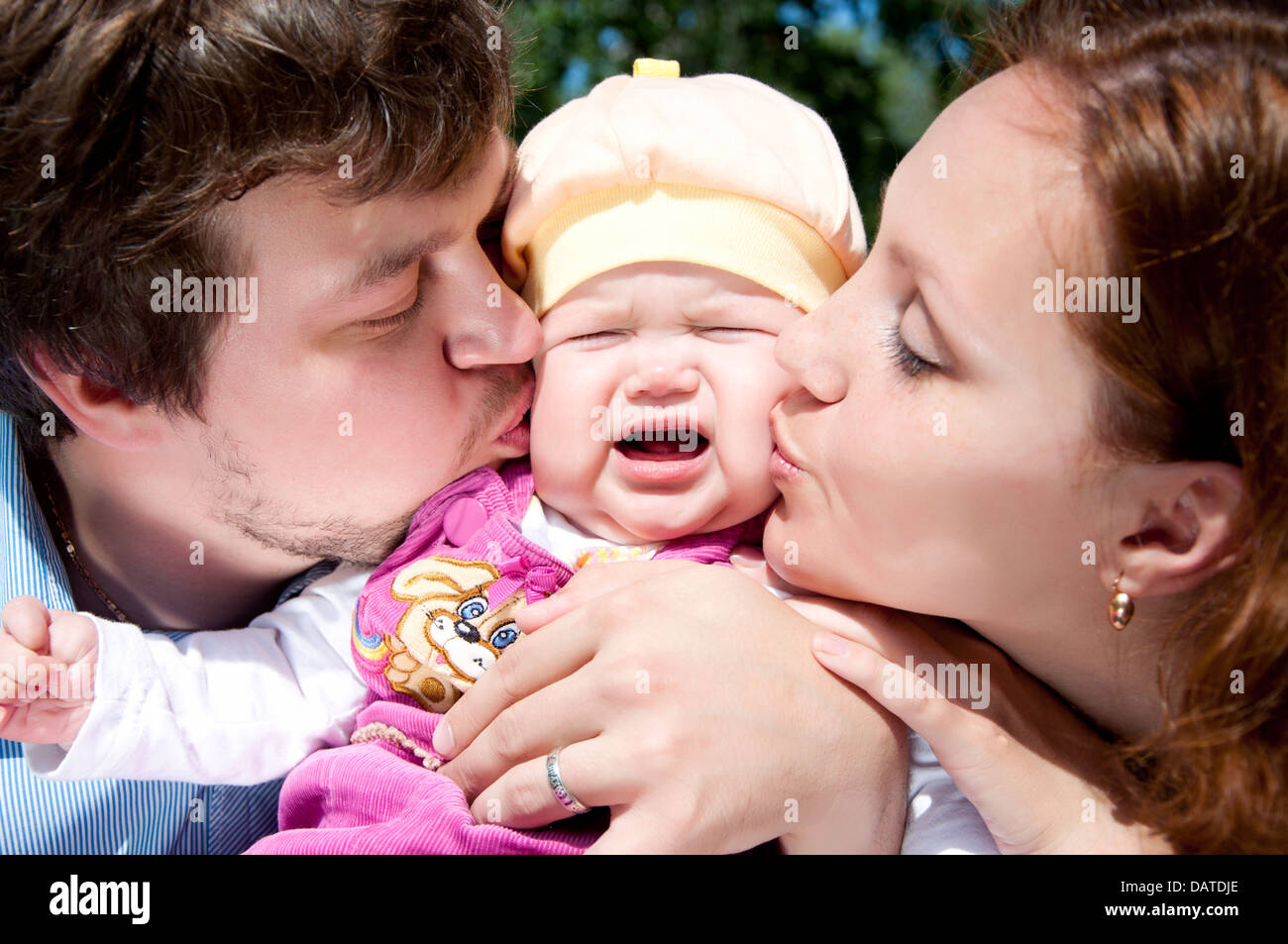 parents kissing baby Stock Photo Alamy