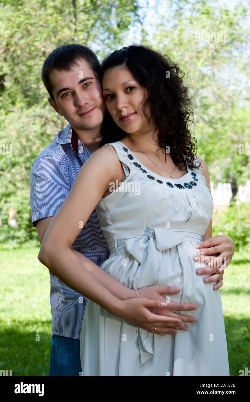 Man and a pregnant woman hugging in the park Stock Photo - Alamy