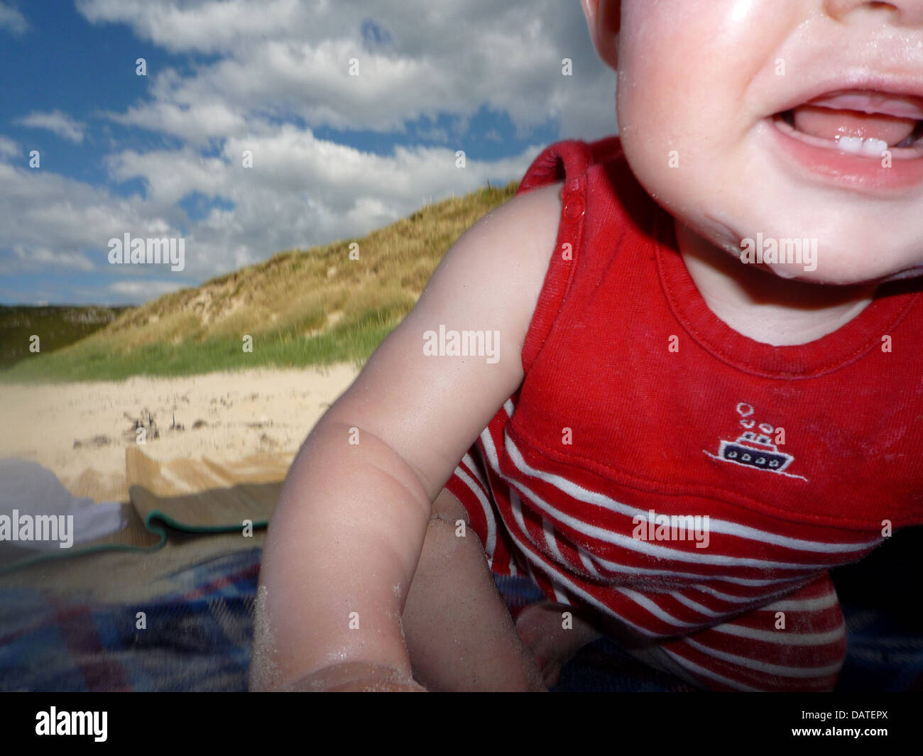 Infant child on beach. Close-up, sand exploration and dribble! Stock Photo