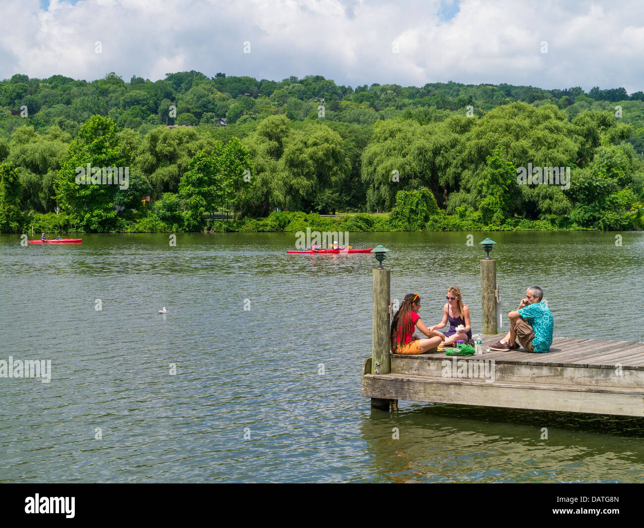 People enjoying summer day on Cayuga Inlet at Steamboat Landing in the Finger lakes region in Ithaca New york Stock Photo