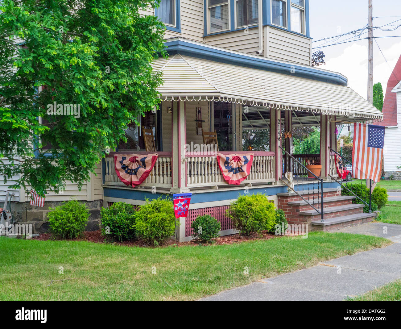 House with flags on porch railings in Watkins Glen New York in the Finger Lakes Region of NY State Stock Photo