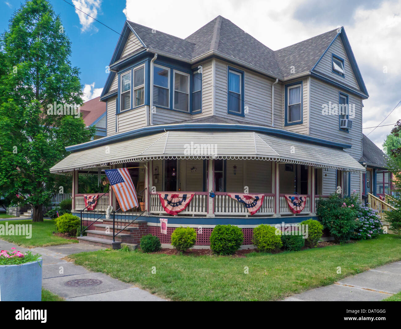 House with flags on porch railings in Watkins Glen New York in the Finger Lakes Region of NY State Stock Photo