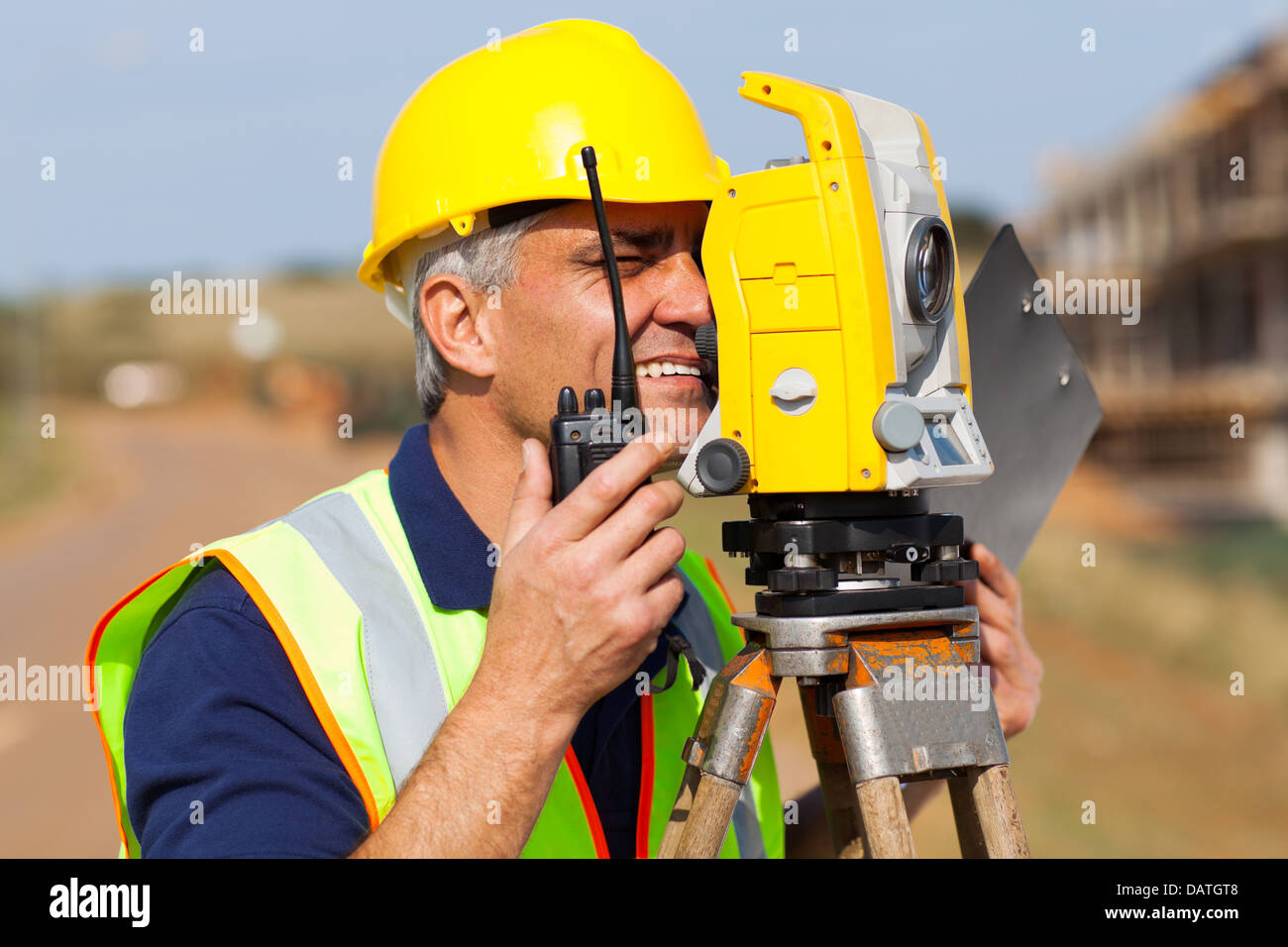 senior land surveyor working with tacheometer on construction site