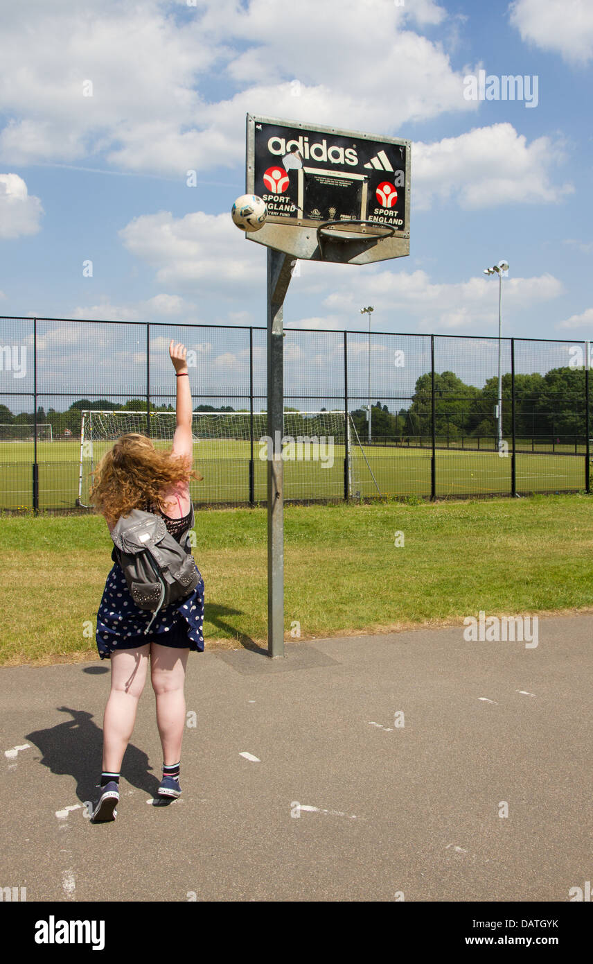 Teenage girl playing netball in the park Stock Photo