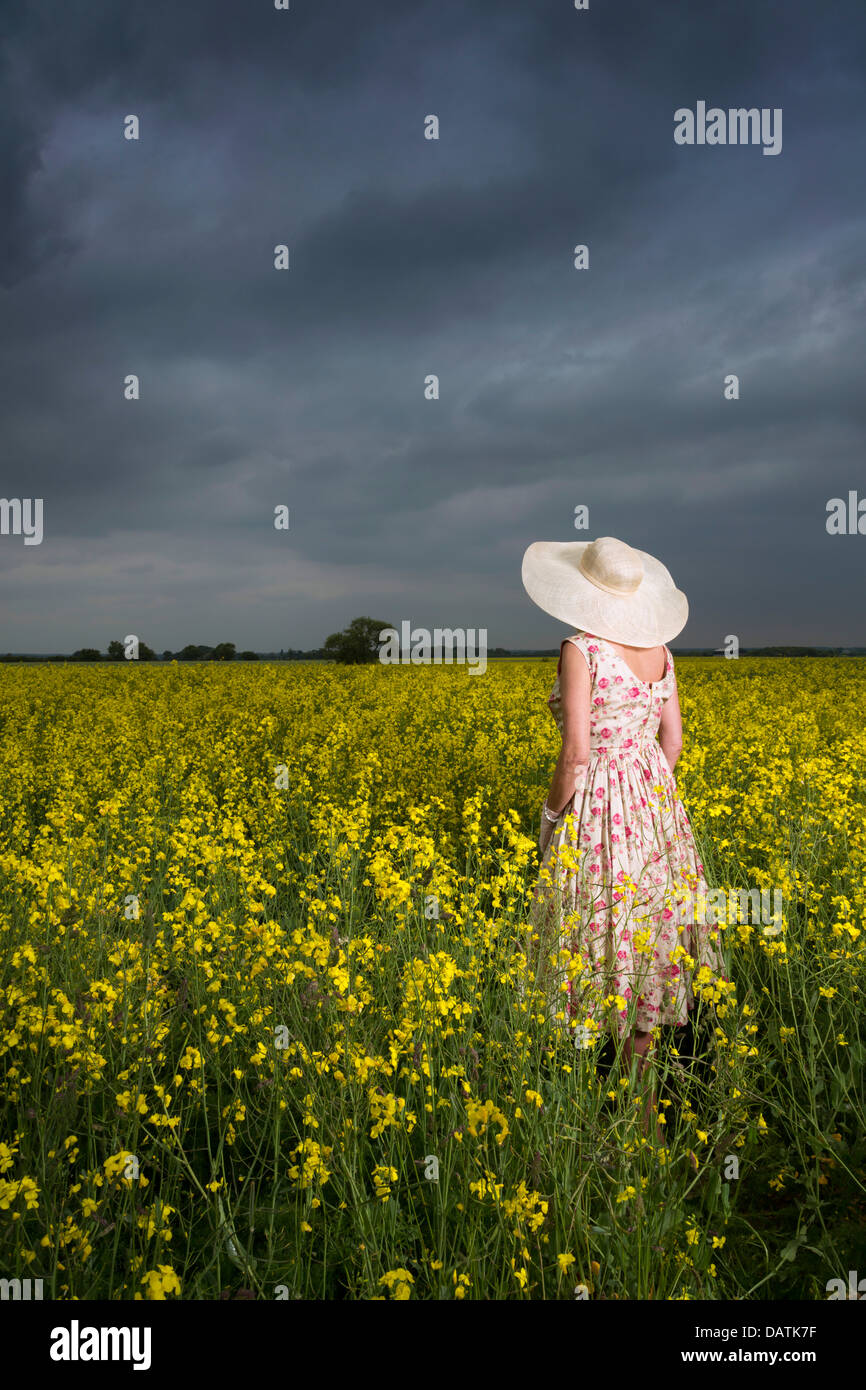 woman standing in field in open countryside with oilseed crop Stock Photo