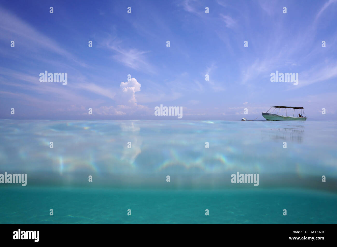 Horizon from the water surface on blue sky with cloud and a boat alone in the Caribbean sea Stock Photo