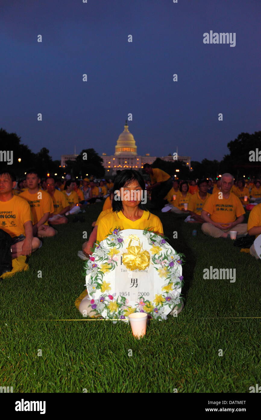 Washington DC, USA. 18th July, 2013. Falun Gong members commemorate the 14th anniversary of the Chinese government crackdown against them which began on 20th July 1999. Some people are holding tributes with the names of those who have been killed during the persecution. In the background is the United States Capitol Building. Credit:  James Brunker / Alamy Live News Stock Photo