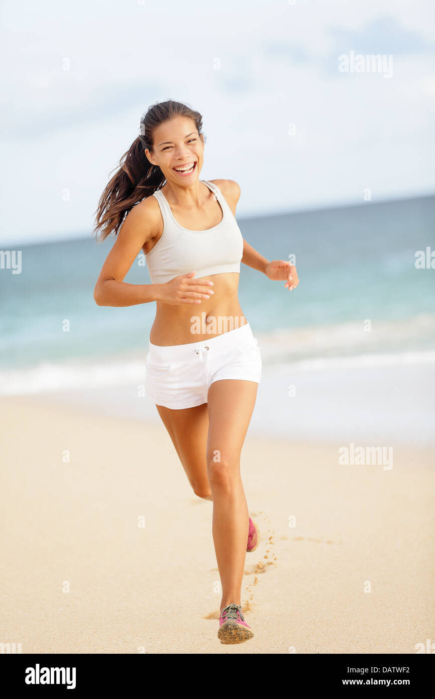 Runner woman running on beach smiling Beautiful vivacious woman jogging on the beach in summer sport shorts laughing she enjoys the Stock Photo - Alamy