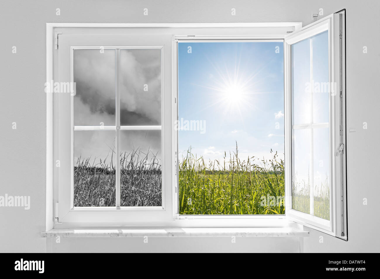 Half open window with view to the outside half on gray storm and half on clouds in blue sky with sun Stock Photo