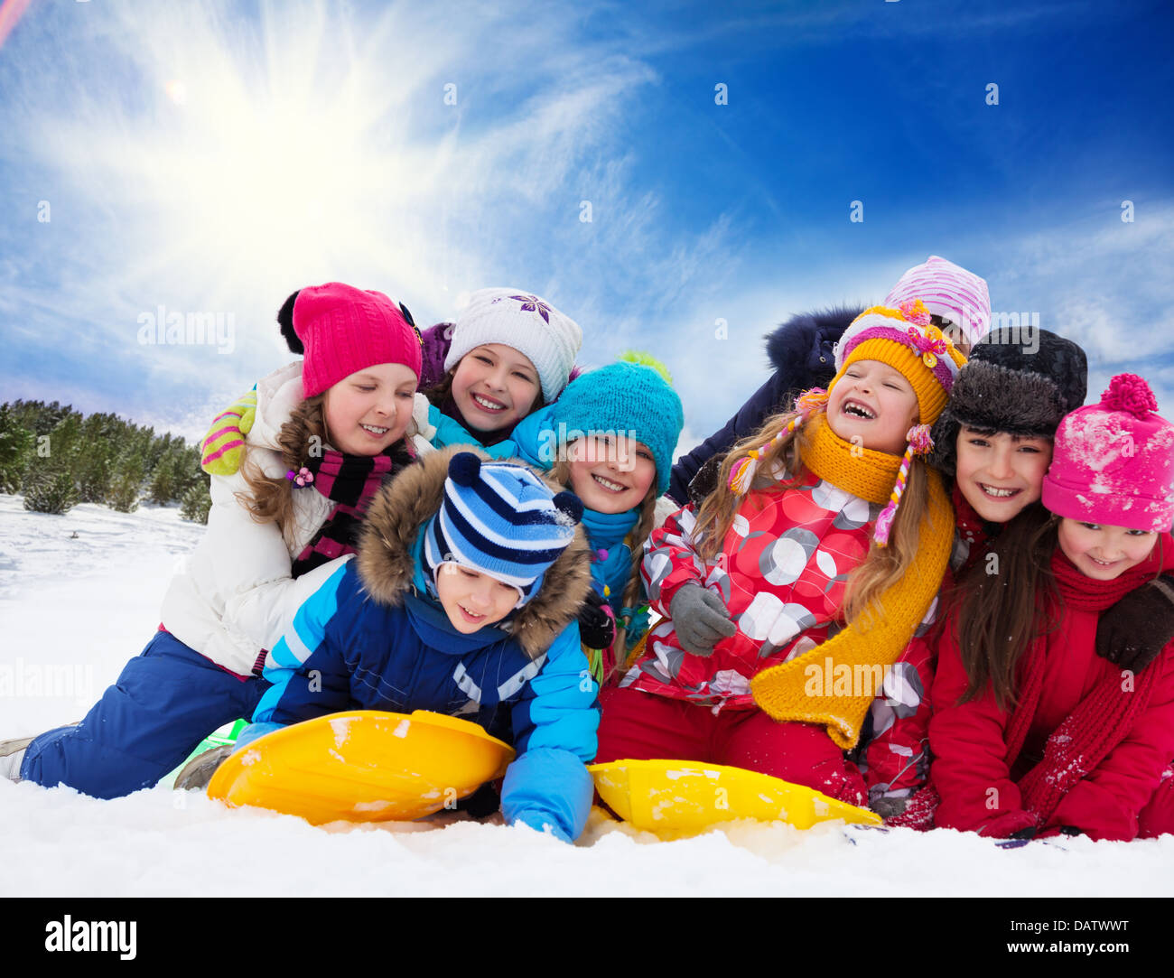 Large group of kids playing together in snow on sunny day Stock Photo ...