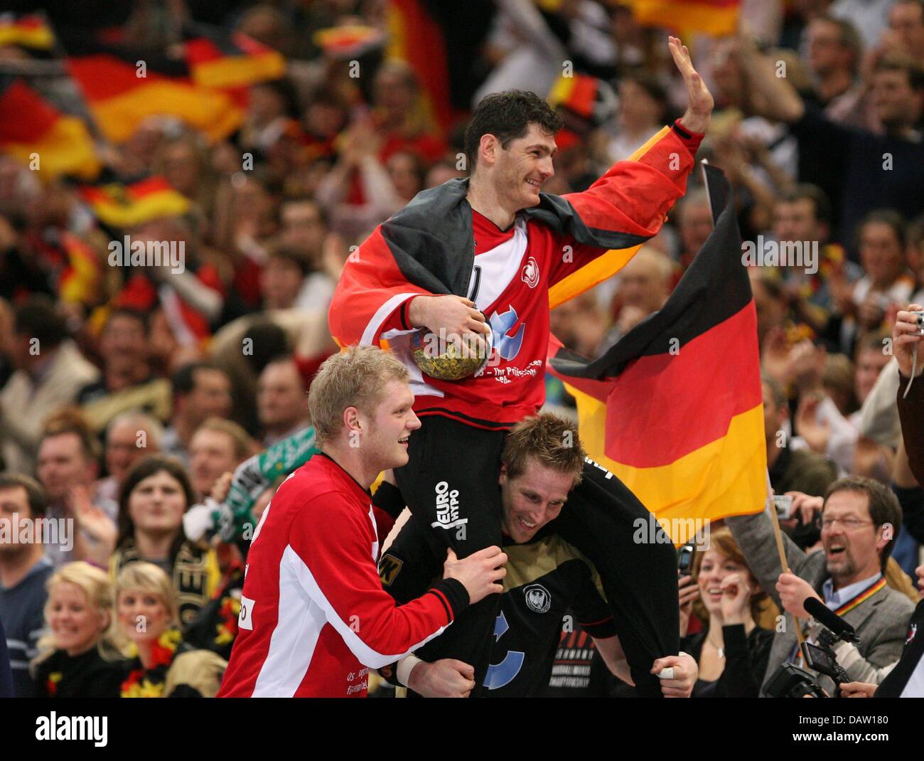 Germany's Oliver Roggisch (R) and Johannes Bitter carry goalkeeper
