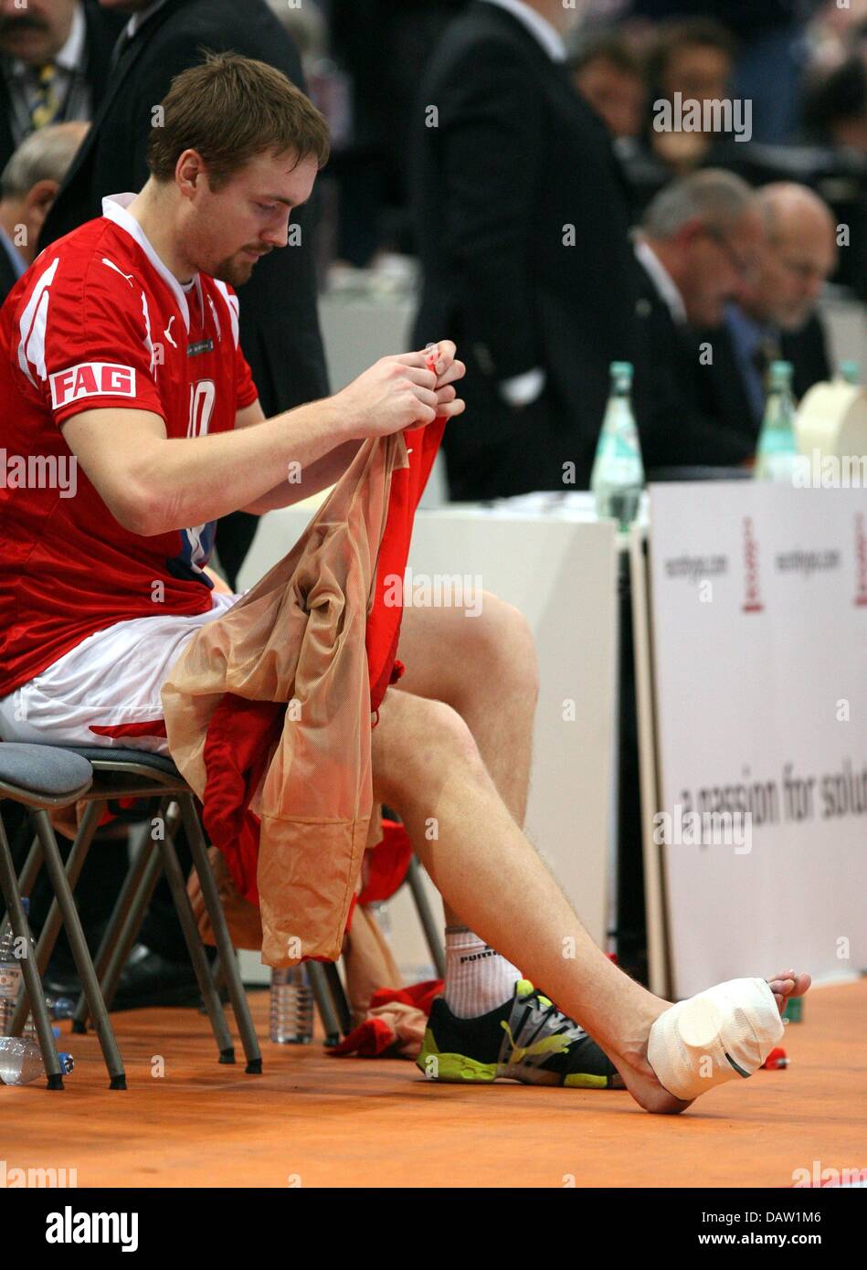 Danish player Lars Moeller Madsen sits with his foot bandaged on the ...